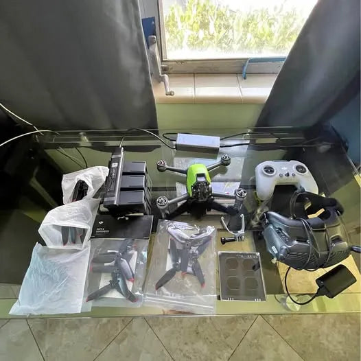 DJI FPV drone kit with controller, FPV goggles, and spare parts on display