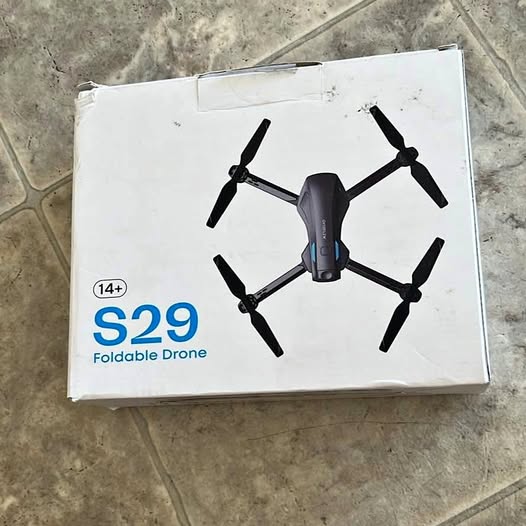 Foldable quadcopter drone with camera, black and gray, on retail box