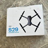 Foldable quadcopter drone with camera, black and gray, on retail box