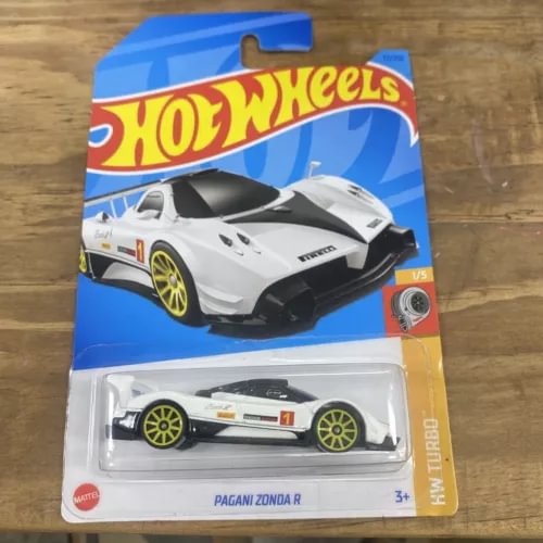Hot Wheels diecast race car model in clear blister, white with black accents, yellow wheels