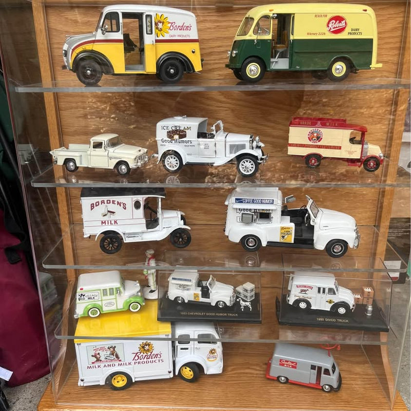 Danbury Mint diecast milk truck set with crates in glass display case, multiple vehicles