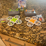 Remote-controlled quadcopter drone set with two remotes and four colorful mini drones