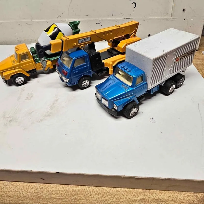 Vintage diecast truck set of three with blue, yellow, and box trucks