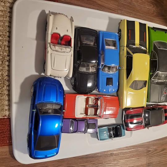 Diecast toy cars in assorted colors on a white tray