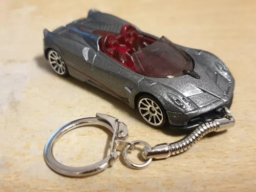 Grey diecast roadster model car keychain with metal keyring and coiled spring