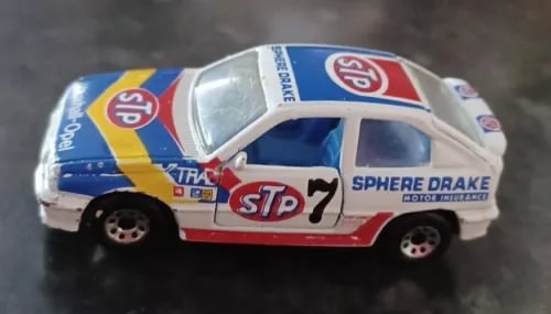 Vintage racing diecast car, white body with blue and red STP livery, side view