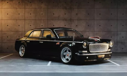 Black diecast luxury sedan model car with chrome grille and whitewall-style tires