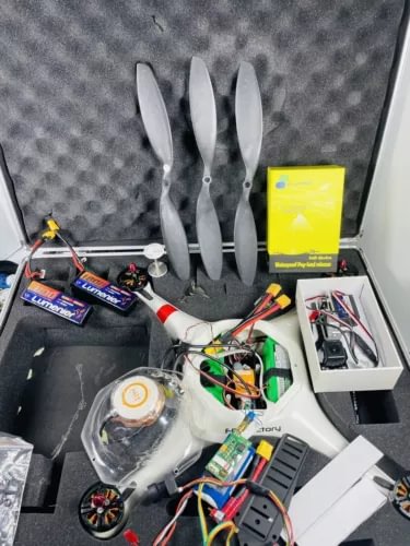 Rugged RC quadcopter drone with exposed propellers and wiring inside open case