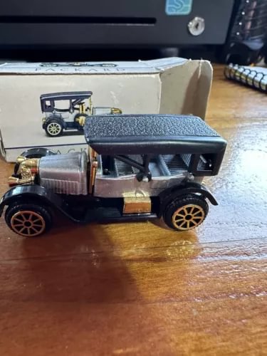 Diecast Packard automobile toy car, dark body with gray roof and gold wheels