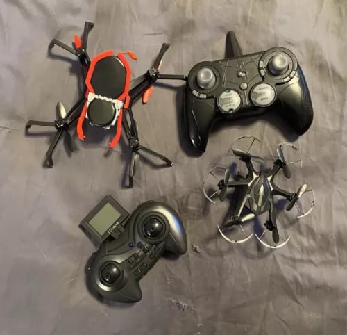 Two RC drones with handheld controller, orange and dark gray