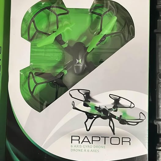 Small drone with green body, front propeller guards, on retail box with BADTOR text