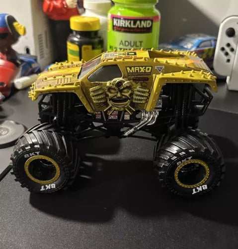 Gold MAX-D diecast monster truck with black oversized tires, detailed chassis and grille