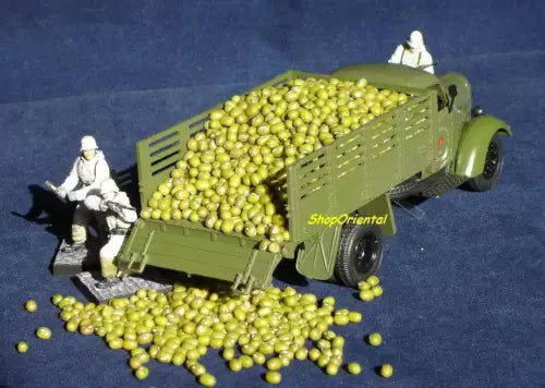 Green diecast transport truck model with soldier figure and bead-like cargo balls