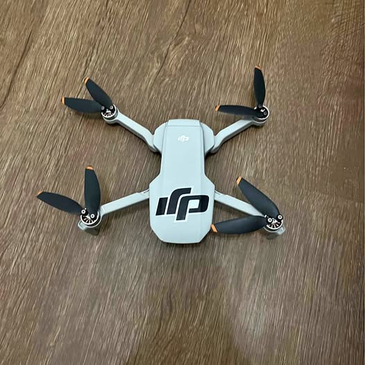 DJI Mini 4K drone with four propellers, light gray body and dark arms