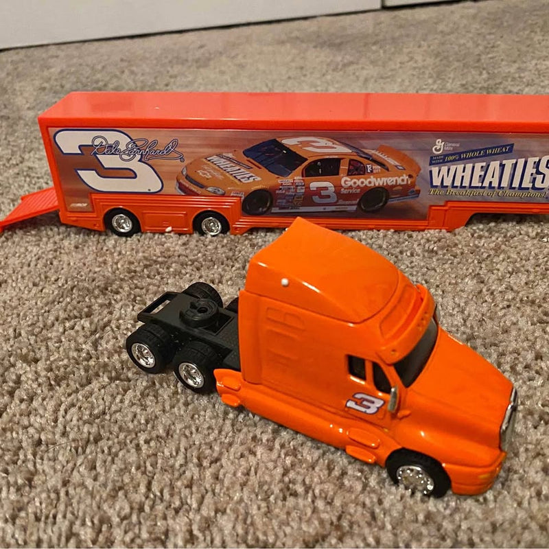 Orange diecast racing truck with black diecast car companion, front and side view