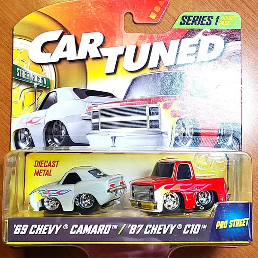 Diecast car two-pack featuring white Camaro and red C10 in retail box