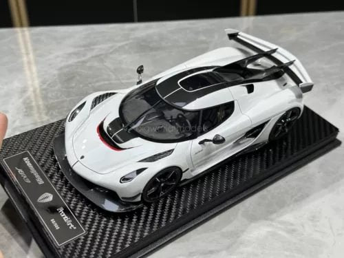 Crystal white diecast sports car model with black details on carbon-fiber display base