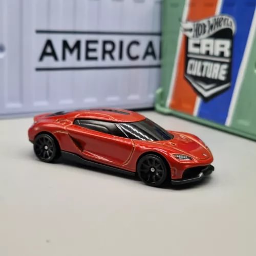 Red diecast sports car model with black hood vents, front 3/4 view