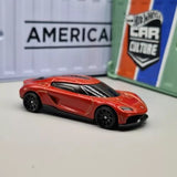 Red diecast sports car model with black hood vents, front 3/4 view