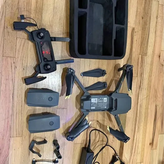 DJI drone with detachable arms and propellers, plus batteries and controller case