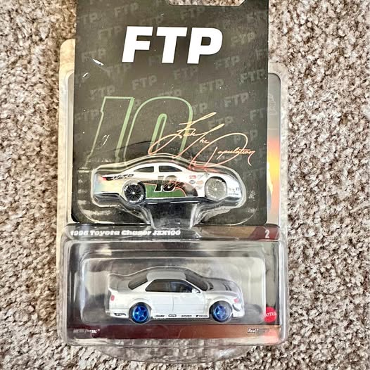 Collectible diecast car in blister pack, white body with blue wheels