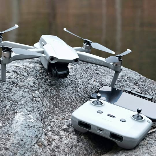White foldable quadcopter drone with four propellers, visible front camera and gimbal.