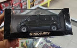 Diecast car model in black display box with MINICHAMPS logo, dark vehicle front view