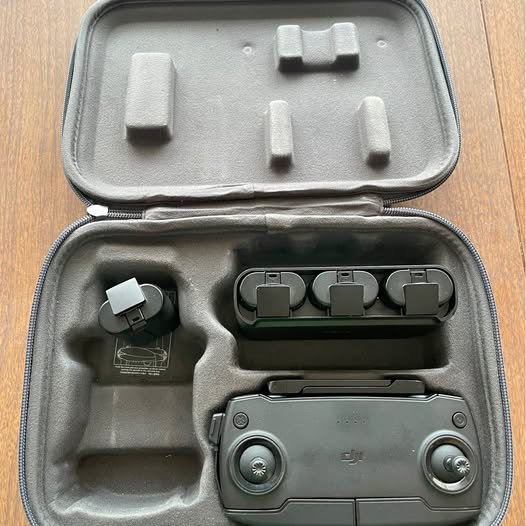 Battery and accessories kit with gray hard case, drone battery, adapter, and parts