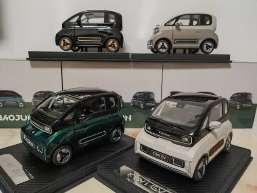 Diecast car model set, one dark green and one light tan with black details.