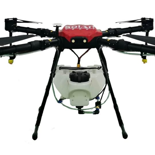 Red and black quadcopter drone sprayer with white tank and central controller unit.