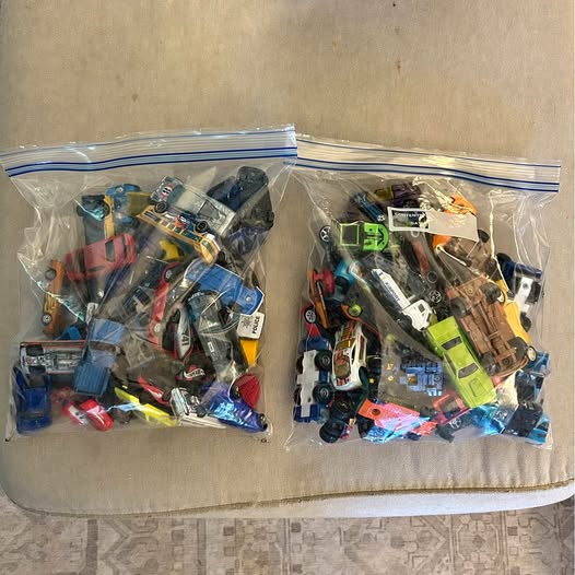 Diecast car lot with assorted miniature cars in clear plastic bags
