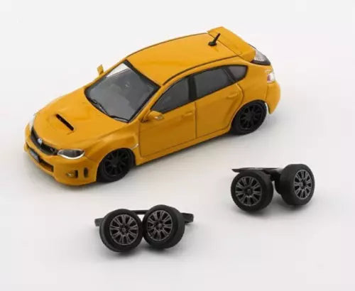 Yellow 1:64 diecast sports car toy with extra wheels, front three-quarter view
