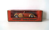 Vintage diecast model car in display box, red-brown with gold accents.