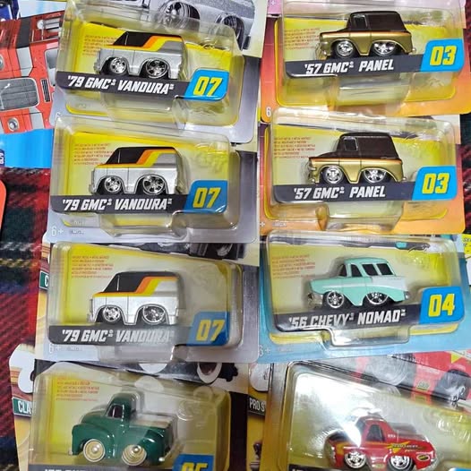 Diecast cars in blister boxes with green and red vehicles, blue number tags.