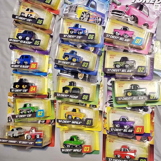 Diecast car model replicas in boxed blister packaging, multiple colors