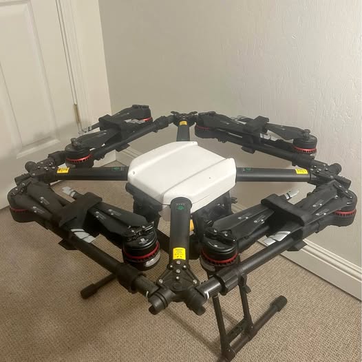 Agricultural spraying drone with radar, dark arms and white central body.