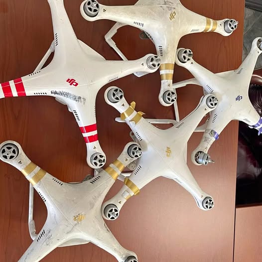 White quadcopter drone frame with propellers and red stripes