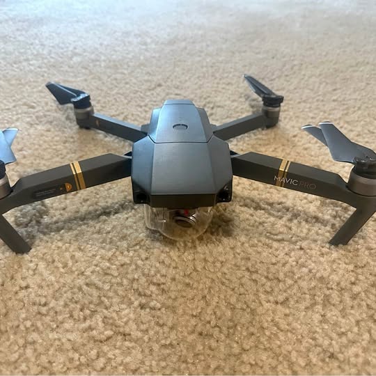 Gray foldable drone with four propellers and center camera housing