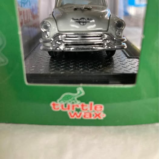 Silver 1/64 diecast classic car front view with chrome grille and headlights