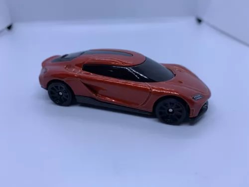 Red diecast sports car model with black hood, side view
