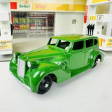 Green classic diecast car model, front three-quarter view with white grille and black wheels
