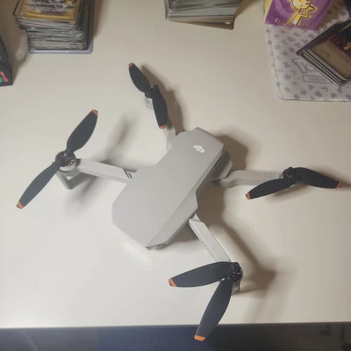 White DJI Mini 2 SE drone with three propellers extended