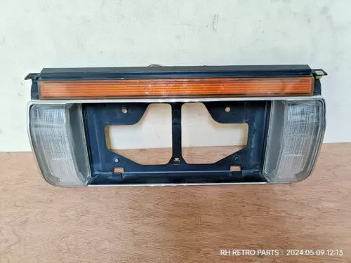 Diecast car front grille with headlights and orange light strip