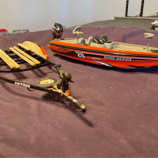 Nitro bass boat diecast model with orange and black hull, on display