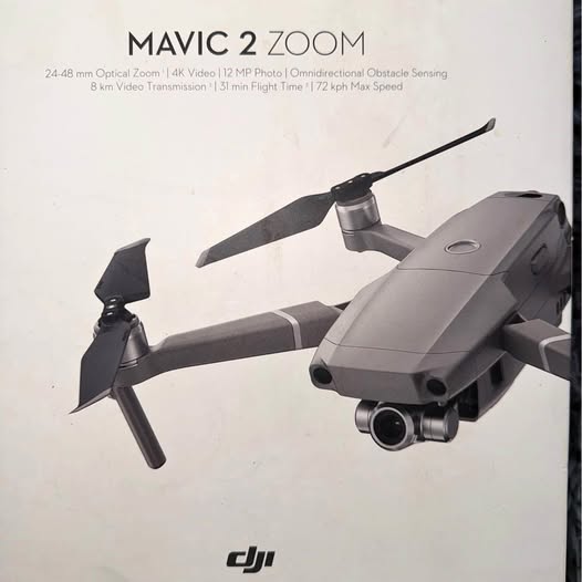 Gray quadcopter drone with gimbal camera, foldable arms and propellers.
