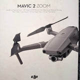 Gray quadcopter drone with gimbal camera, foldable arms and propellers.