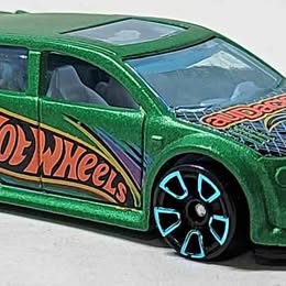 Hot Wheels diecast toy car in green with black accents and Hot Wheels logo, front 3/4 view