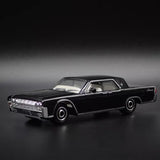 Black die-cast model car with chrome grille and headlights, white interior