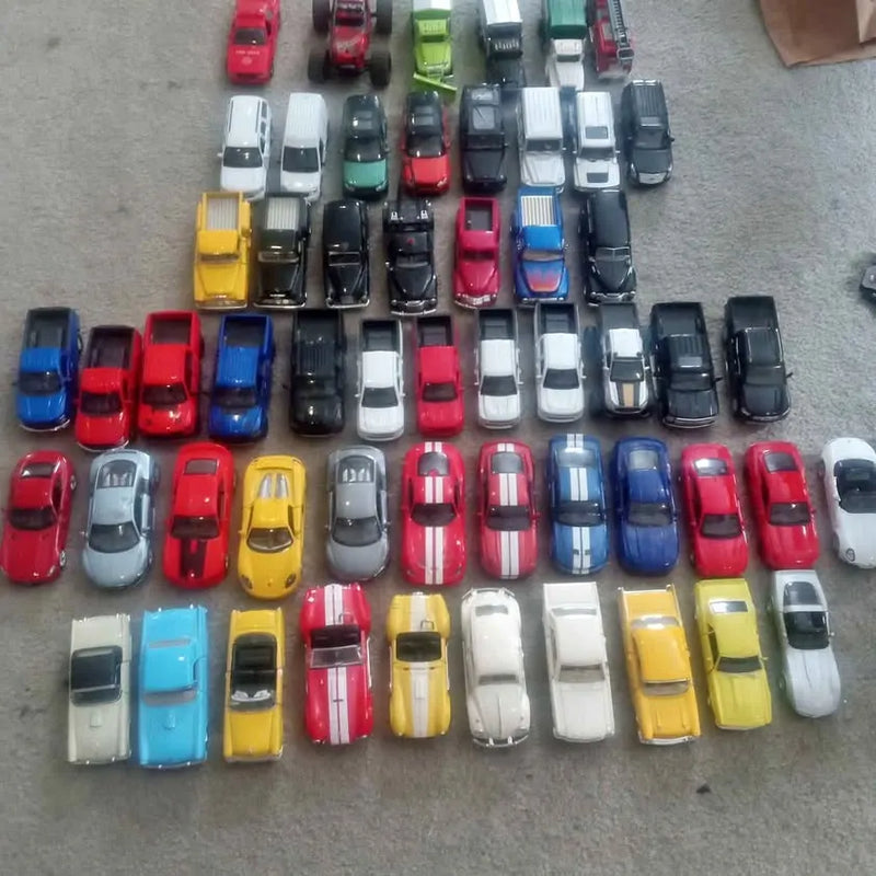Assorted diecast toy vehicles in red, blue, yellow, and gray rows on display