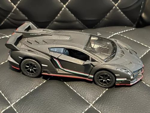 Diecast sports car hardtop, gray with black wheels, side detailing, 1:36 scale.
